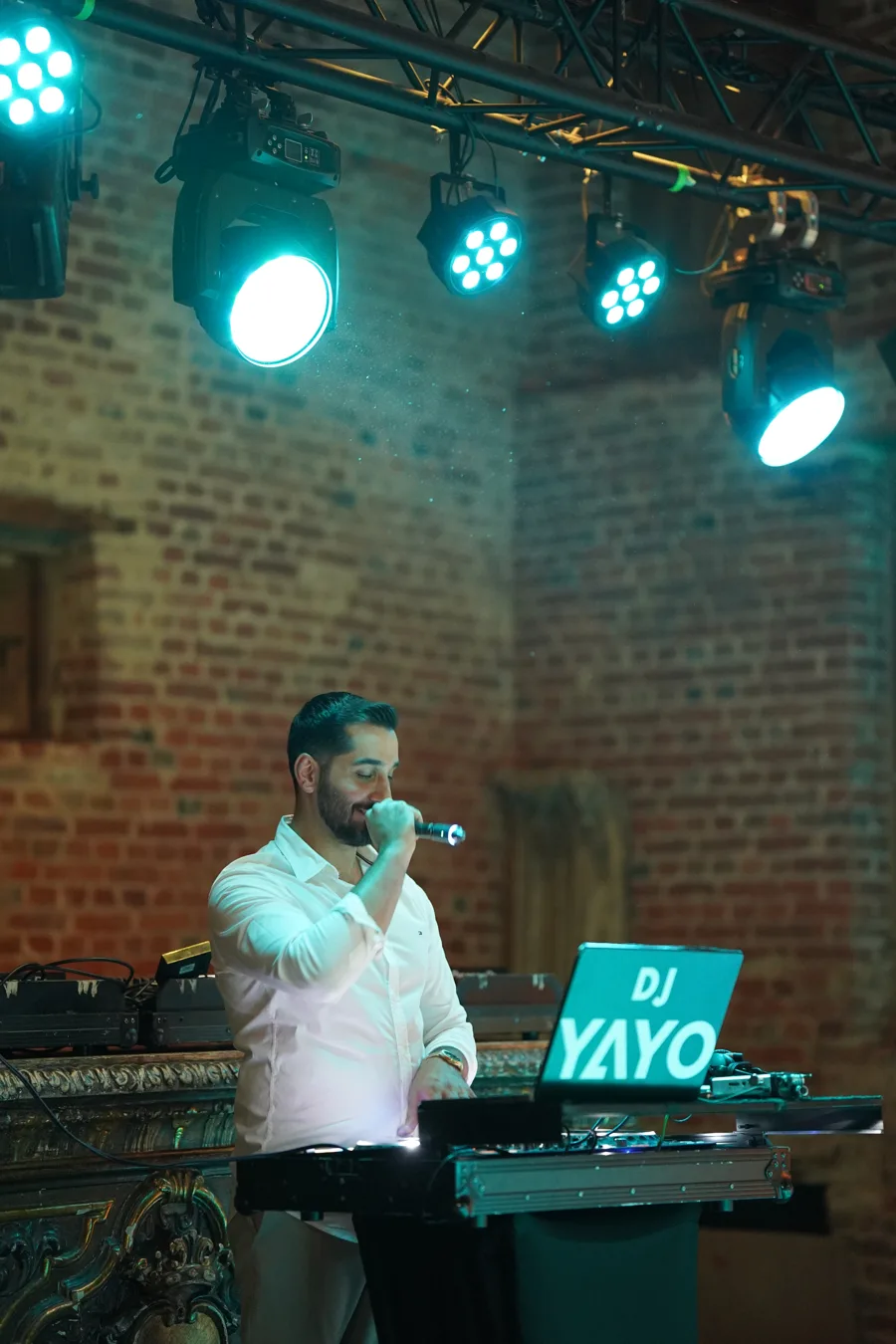 DJ YAYO konzentriert am Pult mit Mikrofon